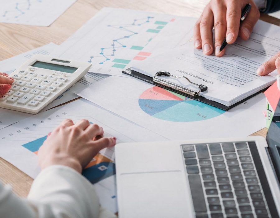 partial-view-of-man-studying-loan-agreement-and-businesswoman-using-calculator-while-sitting-at-e1637859148903-pglchexsppq7jtt0u39geae15iucajt0xxips1r8ew